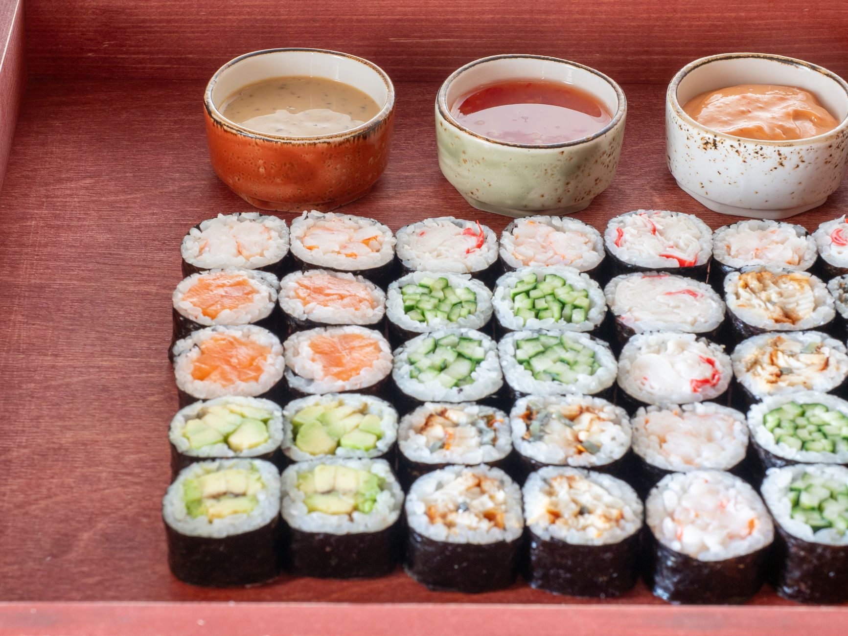 Tri druhy sushi vedľa seba na doske